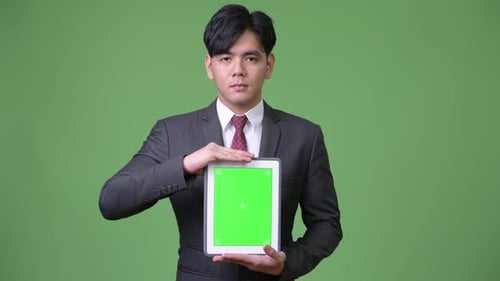 Young Adult Holding Tablet with Green Screen