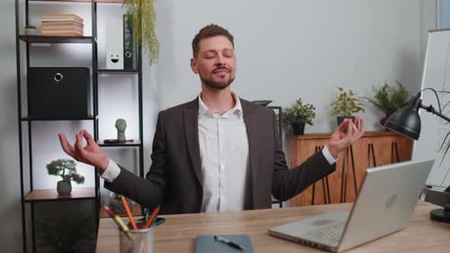 Businessman Working on Laptop Meditating Doing Yoga Breathing Exercise in Lotus Position at Office