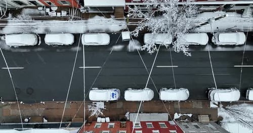 Top down aerial above street during winter sleet and snow flurries. Residential urban district.