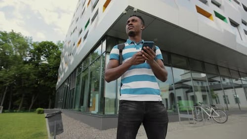 Young Man Using Smartphone in City Setting