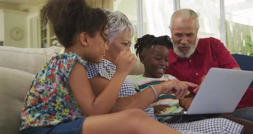 Family Enjoys Laptop Together on Sofa Indoors