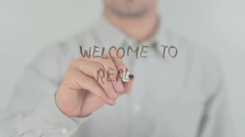 Writing Welcome to Reality on Clear Glass Surface