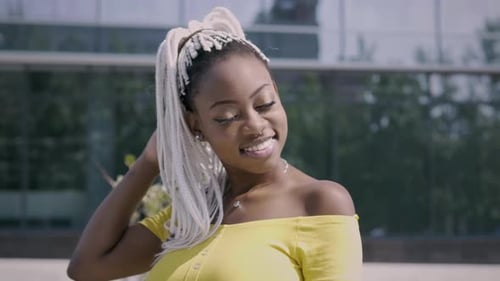 Smiling Woman with Braids Poses in Urban Setting