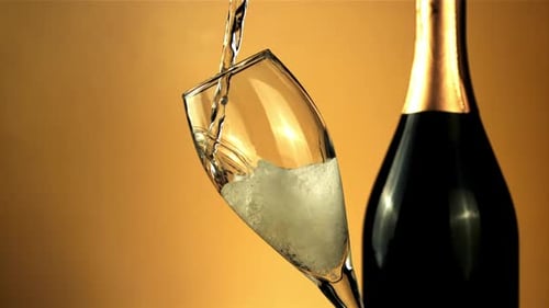 Stream of Champagne Pours Into a Glass of Air Bubbles