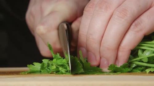 Chopping Fresh Parsley on a Cutting Board