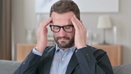 Man in Jacket Rubbing Temples With Headache