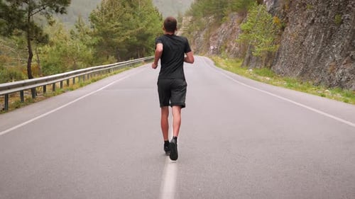 Athletic Young Adult Jogging Down a Rural Road