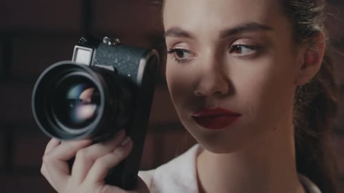 Stylish Woman Photographer with Retro Photo Camera Smiling Into Camera in Studio
