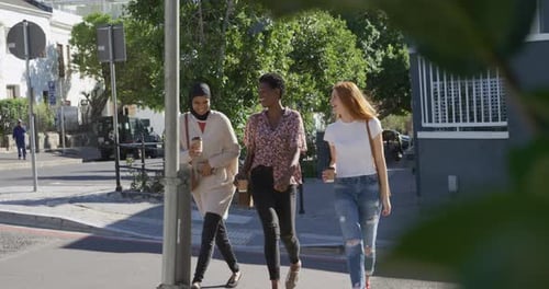 Three Friends Walking and Talking with Coffee