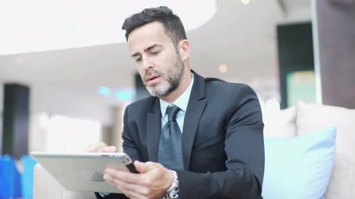 Man in Suit Works on Tablet in Office