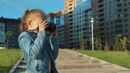 Young Child Taking Photos in an Urban Park