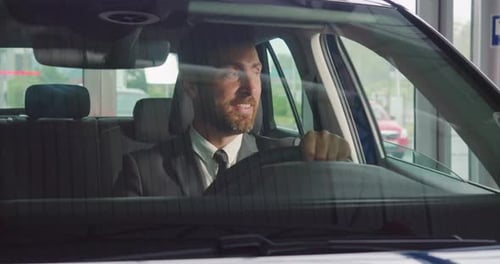 Adult Man Smiling in a Car at Dealership