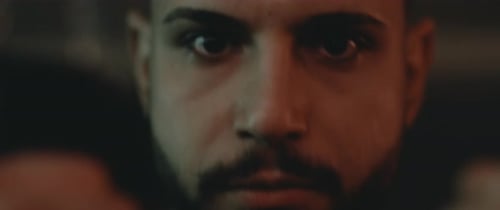 Intense Man Clenches Fists in Dramatic Lighting