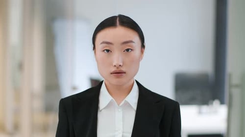 Professional Woman in Blazer Blinking, Office Setting