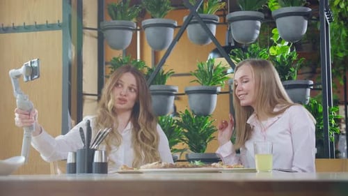 Two Women Using Smartphone for Video Blog at Cafe