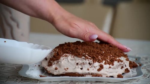 Une femme couvre un gâteau avec des miettes de biscuits