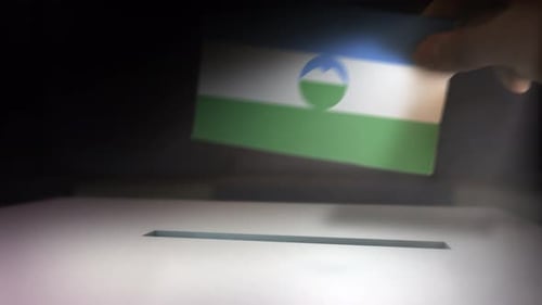 Hand Inserts Flag Ballot Paper into Election Box