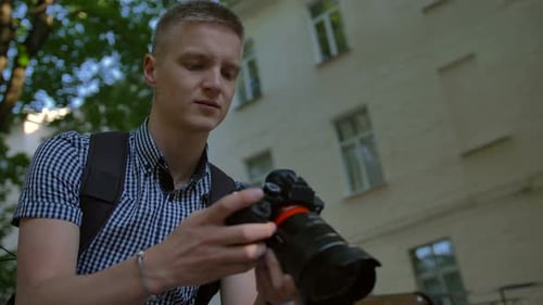 Young Adult with Camera Outdoors in City