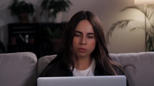 Woman Uses Laptop at Home on Couch