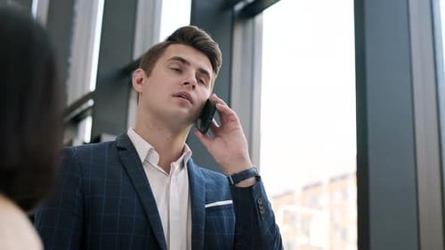 Young Adult Talking on Cell Phone in Office