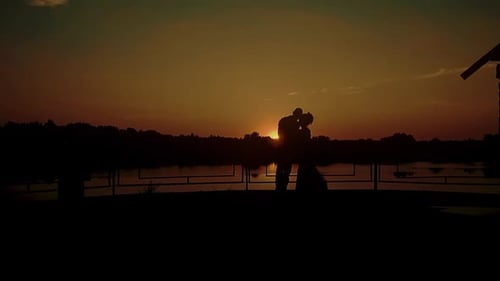 Two Young People Hugging Against the Backdrop of a Sunset By the River Slow Motion