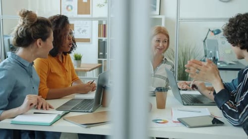 Happy Women Colleagues Talking and Doing Highfive Enjoying Successful Work Together in Office