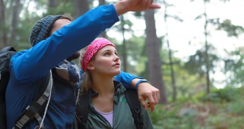 Happy Couple Hiking Together Through Green Forest