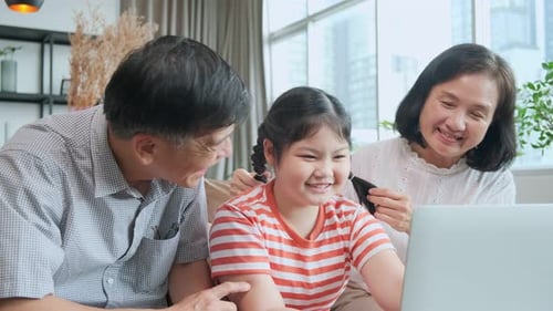 Cheerful Family Using Laptop Together at Home