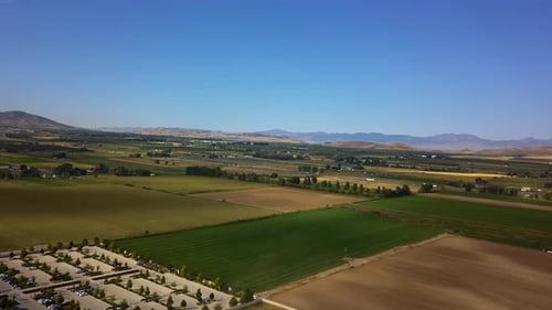 Drohnenaufnahme von grünen und gelben quadratischen Ackerlandflächen in Payson Utah.