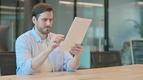 Frustrated Man Examining Documents in Bright Office