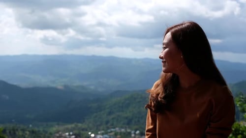 A beautiful female traveler looking at a beautiful mountain and nature view