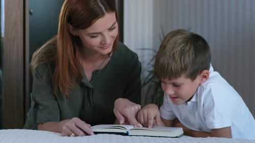 Mother Reading Book with her Son Indoors