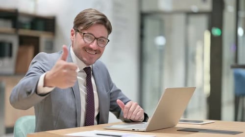 Thumbs Up By Positive Businessman Working in Office