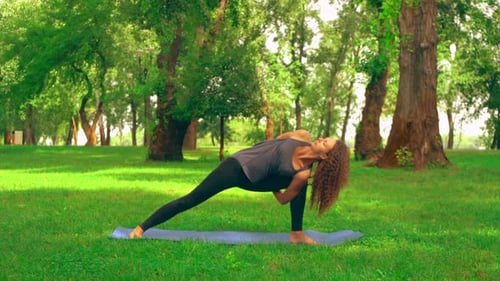 Woman Practicing Yoga in a Green Urban Park