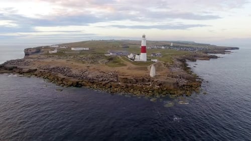 Lighthouse on the cliff aerial view at dusk in England