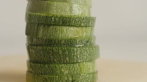 Green slices of Pepo cylindrica on cutting board close-up 4K 2160p 30fps UltraHD tilting footage -
