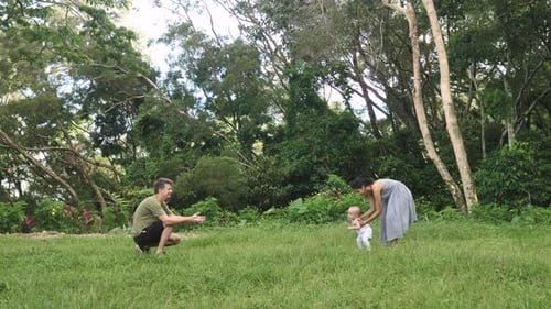 Parents Helping and Encouraging Their Little Baby Boy to Walk Do First Steps