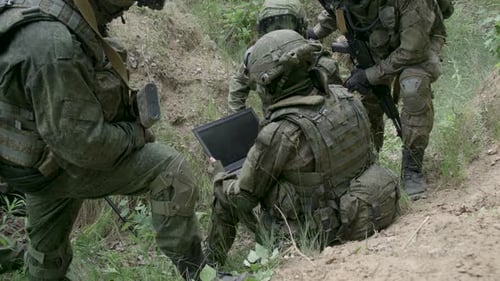 Soldados camuflados em emboscada Engenheiro militar usa um sistema de navegação de laptop Ação militar