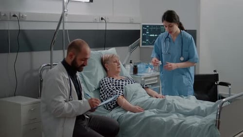 Doctor Consulting Sick Patient in Bed with Nasal Oxygen Tube
