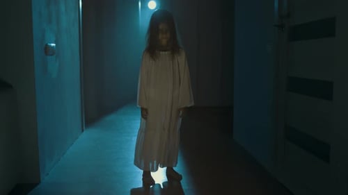 Eerie Child in White Gown Stands in Hallway Eerie Child in White Gown Stands in Hallway