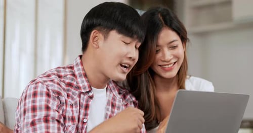Happy Couple Using Laptop Indoors Together