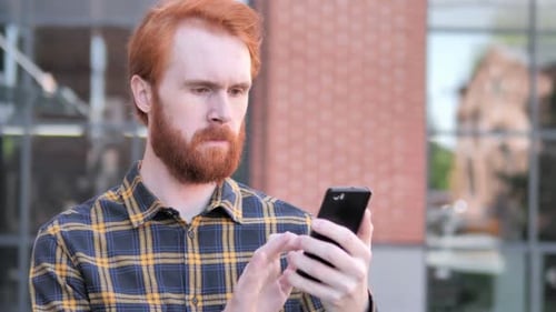 Young Man Using Mobile Phone Outside Building