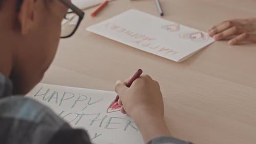 Children Drawing Mother's Day Cards at Table