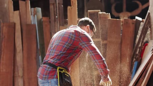 Carpenter working on woodworking machines in carpentry shop.