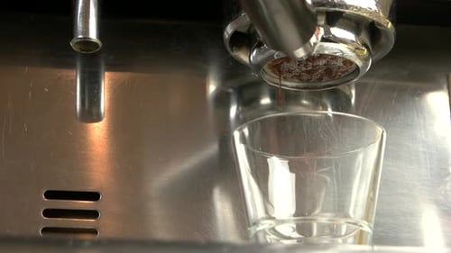 Espresso Pouring into Glass Cup From Machine
