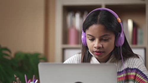 Young College Student Girl with Headphones Studying on Computer at Home