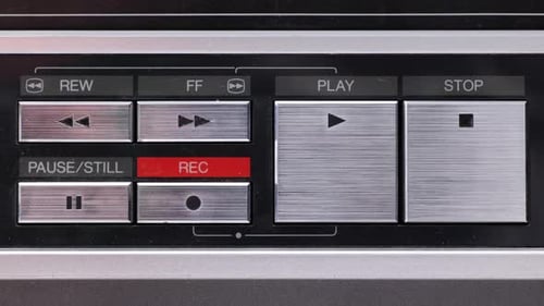 Gros plan extrême des boutons d'un vieux magnétoscope ancien ou vintage, un doigt entrant et appuyant sur Play.