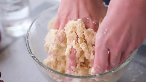Hands Mixing Dough in Glass Bowl Close Up