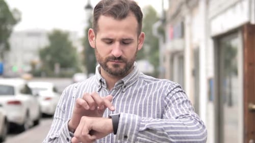 Man Using Smartwatch on City Street