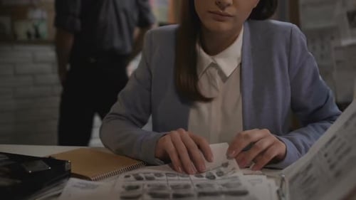Detective Woman Reviewing Evidence with Male Detective